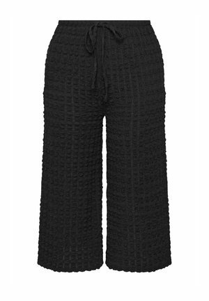 Pantalones anchos de punto texturizado en color negro, con cinturilla elástica y cordón ajustable.