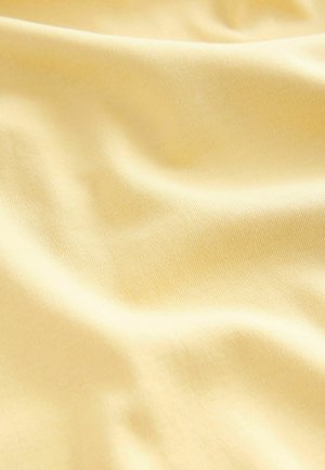 Cotton fabric in a soft, light yellow shade, featuring a smooth, slightly textured surface with gentle waves and folds.