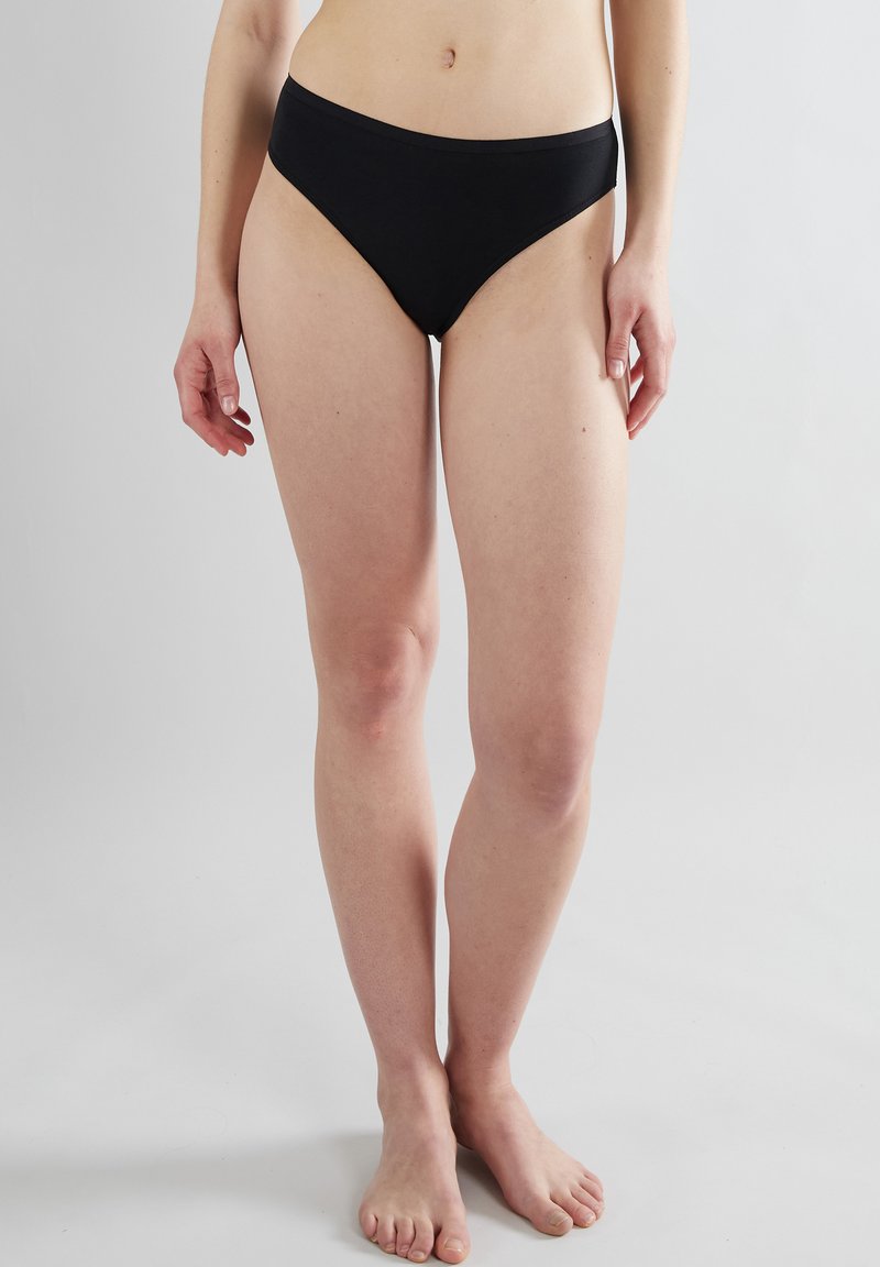 Zwarte katoenen bikini slipjes met een hoog uitgesneden pijpdesign en elastische tailleband. Smooth textuur zonder zichtbare patronen of hardwareaccenten.