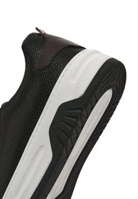 Sneaker nera texturizzata con accenti marroni, presenta una suola intermedia bianca e una suola in gomma con motivo per una migliore aderenza.