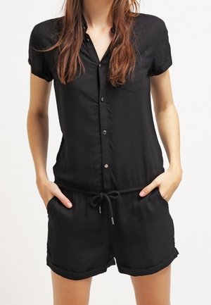 Tuta nera a maniche corte con chiusura frontale a bottoni, vita con coulisse e polsini arrotolati, realizzata in tessuto leggero.