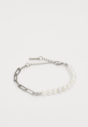 Sidabrinė grandinėlė su pakaitinėmis jungtimis ir dramblio kaulo spalvos perlamutrais, su krabų užsegimu ir reguliuojamu grandinėlės detaliu.