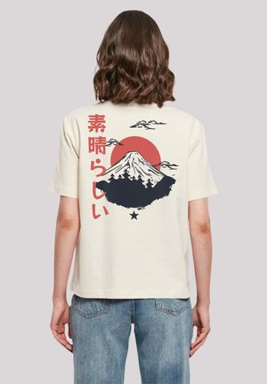 Cream cotton t-shirt featuring a graphic of Mount Fuji, red sun, and text in Japanese; relaxed fit and short sleeves.