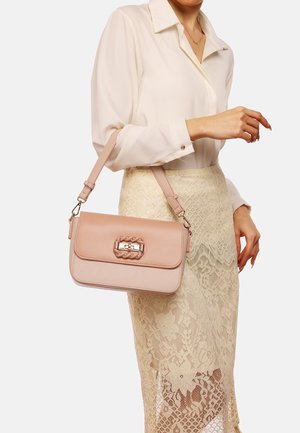 Borsa a tracolla rosa chiaro di forma rettangolare, con un dettaglio intrecciato sulla chiusura e una tracolla regolabile. Texture liscia, design minimalista.