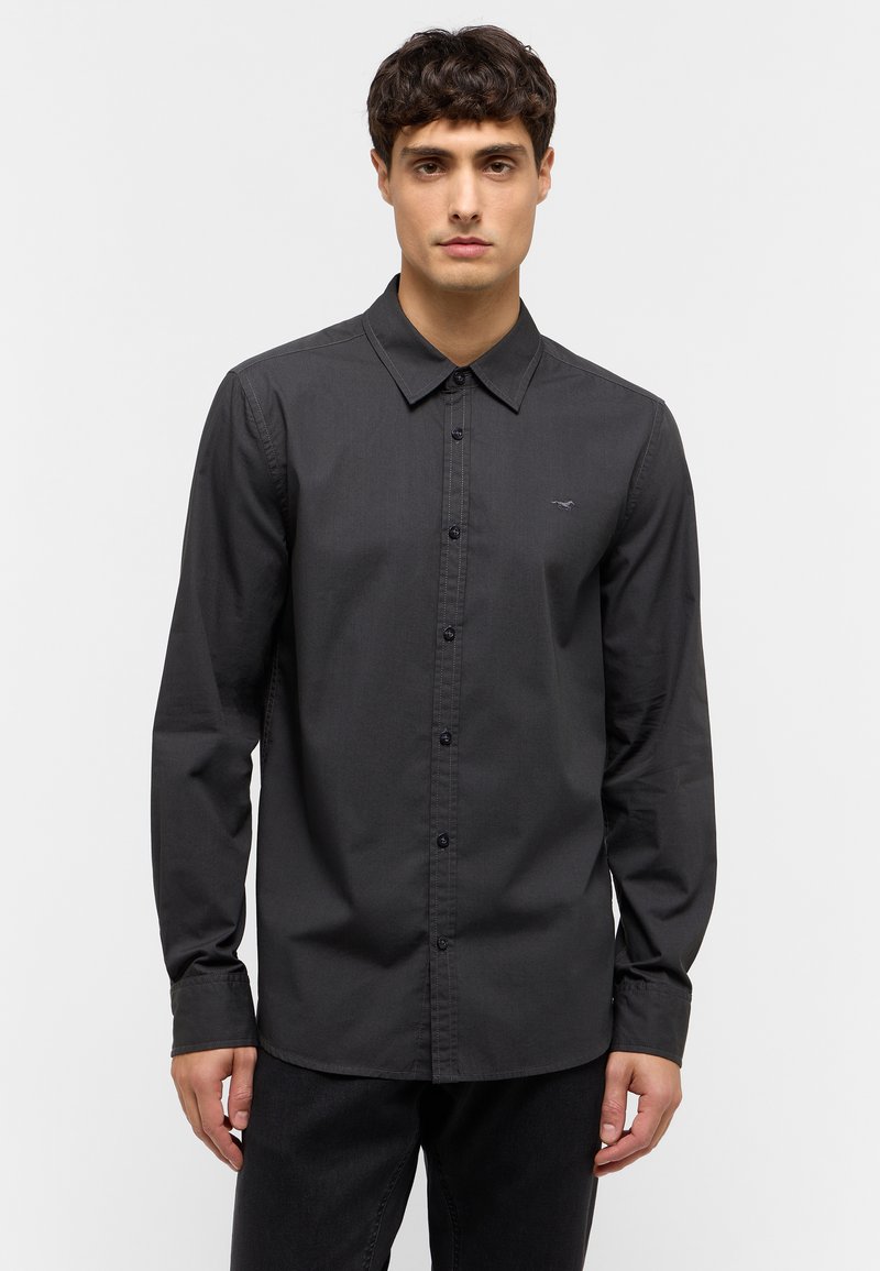 Camisa negra de manga larga con botones, hecha de una tela suave. Presenta un collar clásico y un sutil logo en el pecho.