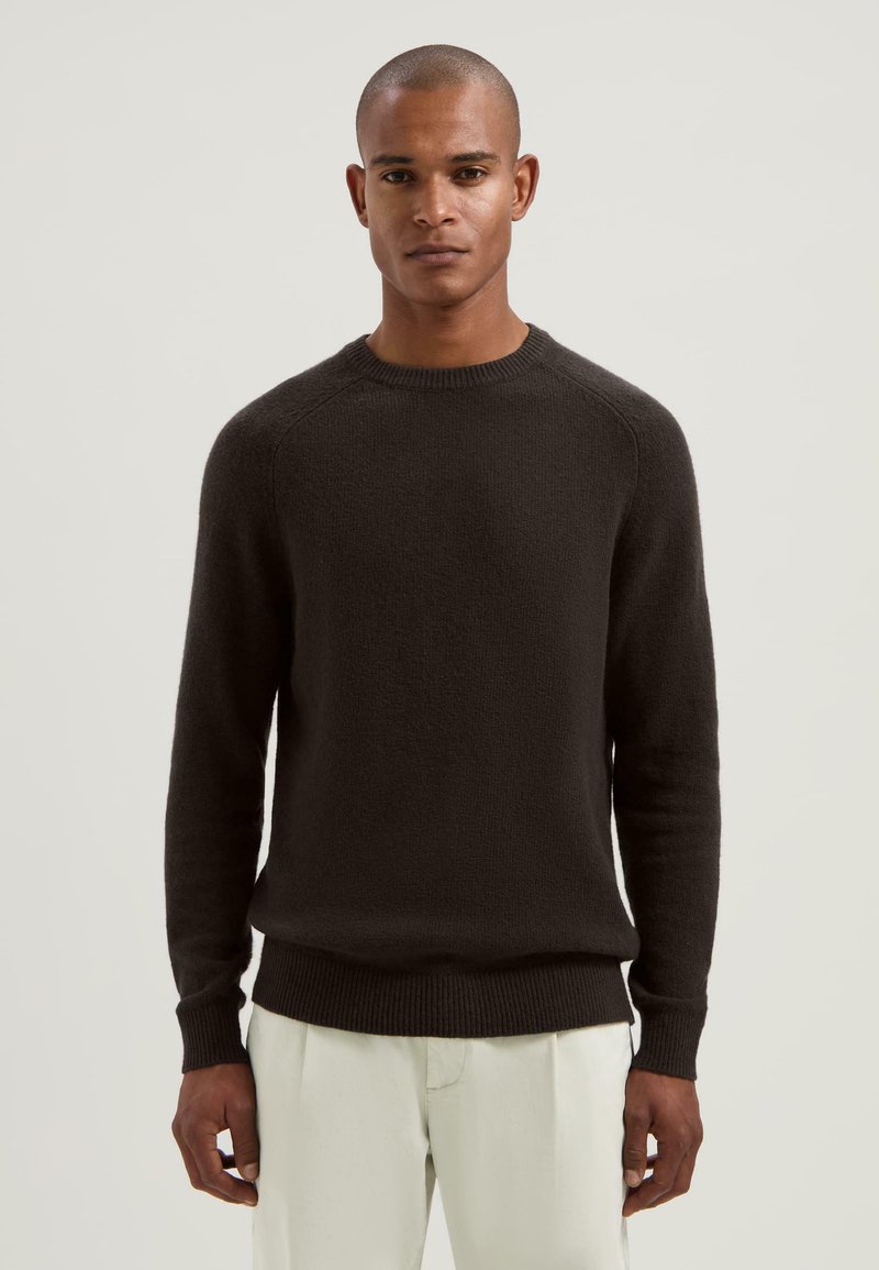 Maglione a girocollo marrone scuro con finitura texturizzata, polsini e orlo a costine, caratterizzato da una vestibilità rilassata e maniche lunghe.