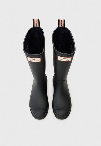 Crne gumene čizmice za kišu s matiranim završetkom, s narančastom i bijelom oznakom loga, te teksturiranim unutrašnjim oblogom.