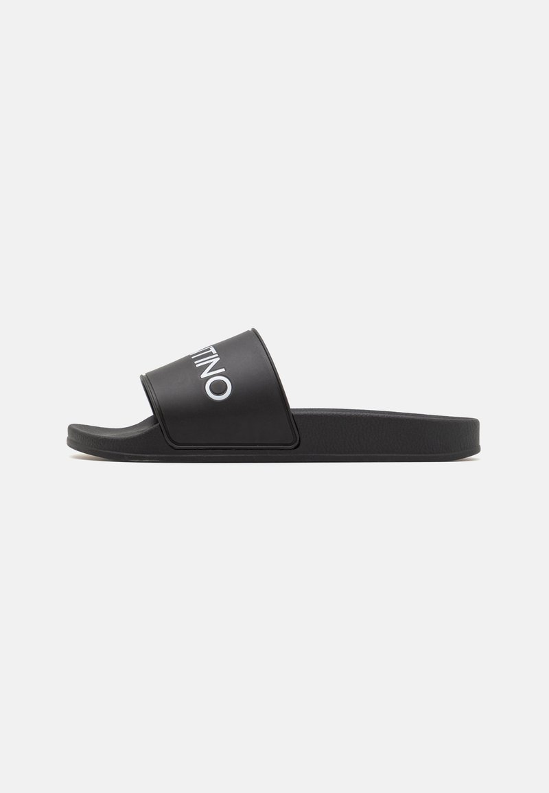 Black slide sandal with a wide strap featuring the logo, made of synthetic material, flat sole, smooth texture, and minimalist design.
