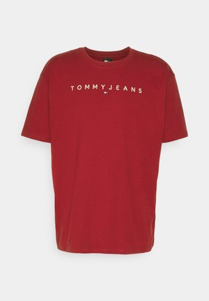 Czerwona bawełniana koszulka z krótkim rękawem z napisem „TOMMY JEANS” i małym logo Tommy Hilfiger na środku klatki piersiowej.