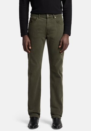 Olijfgroene jeans van katoen, met een rechte pasvorm, een vijf-pocket ontwerp en metalen hardware, gekleed met zwarte enkellaarzen.