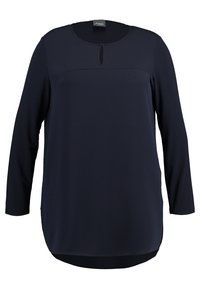 Námořnická modrá dlouhá halenka s kulatým výstřihem a malým detailem ve tvaru klíče. Hladký materiál s mírně prodlouženým zadním lemem.