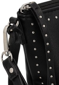 Borsa a mano nera in ecopelle con borchie argentate, chiusura con zip e tracolla regolabile, caratterizzata da una finitura testurizzata e dettagli in metallo.