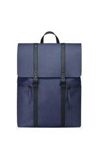 Navy blue backpack with a fold-over flap, black straps, front zip pocket, and embossed logo. Made of durable material with a smooth texture.