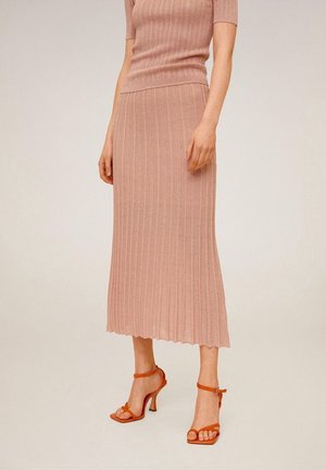 Helles rosa gestricktes Zweiteiler-Outfit mit einem ribbeligen Kurzarmoberteil und einem Midirock mit flarem Saum, kombiniert mit orangefarbenen High-Heels.