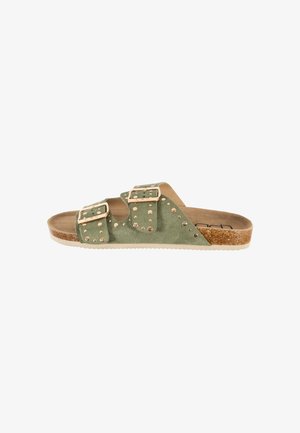 Sandale mule en daim vert avec deux brides réglables à boucle, clous en or rose, semelle intérieure en liège et semelle extérieure blanche.
