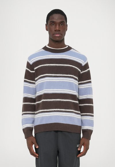 Pull en tricot aux rayures marron, bleu clair et blanc. Doté d'un col et de poignets côtelés. Texture douce, coupe décontractée.