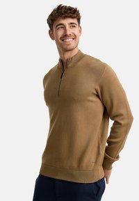 Brauner, leichter Pullover mit halblangem Reißverschlusskragen, gerippten Bündchen und Saum. Hat eine glatte Textur und ein dezentes Logo-Detail in der Nähe des Saums.