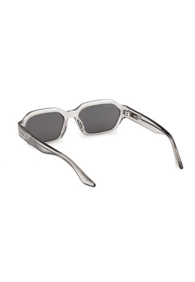 Gafas de sol con montura gris transparente y lentes rectangulares oscuras, inclinadas para mostrar el interior y las varillas.
