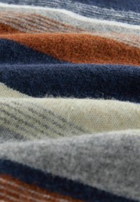 Woolen fabric with diagonal stripes in navy, rust, beige, and grey, featuring a soft texture and varying thickness. Accent pattern includes subtle lines.