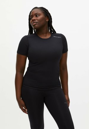 Black fitted athletic shirt with short sleeves, textured fabric, and logo on the shoulder. Worn with matching black leggings.