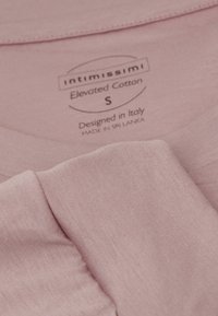 Camiseta de algodón rosa claro con una textura suave, cuello redondo y etiqueta que dice "Intimissimi", talla S, diseñada en Italia, confeccionada en Sri Lanka.