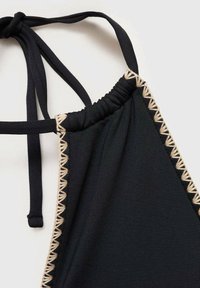 Schwarzer Badeoberteil mit verstellbaren Trägern, zeichnet sich durch Raffungen und eine dekorative beige Naht entlang der Kanten aus. Glatte Stofftextur.