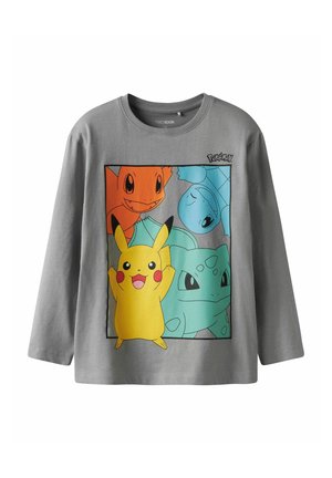 T-shirt gris à manches longues avec un design graphique de personnages Pokémon : Pikachu en jaune, Carapuce en bleu, Salamèche en orange et Bulbizarre en vert.