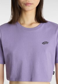 Laventeli lyhythihainen t-paita, joka on valmistettu puuvillasta. Siinä on lyhyet hihat ja edessä musta logopatchi, jossa lukee "VANS OFF THE WALL".
