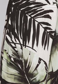 Černý a zelený potisk palmových listů na světlém materiálu. Obsahuje různé tvary a textury listů. Elastický pas v horní části.