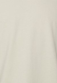 Ljust beige bomull T-shirt med en slät textur och avslappnad passform. Inga synliga mönster eller grafik. Enkelt och minimalistiskt design.