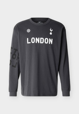 Σκούρο γκρι μακρυμάνικο μπλουζάκι Nike με την επιγραφή "LONDON" σε λευκό κείμενο, το λογότυπο της Tottenham Hotspur και floral σχέδιο στο μπροστινό μέρος, μαύρο σχεδιασμένο αριστερό μανίκι.