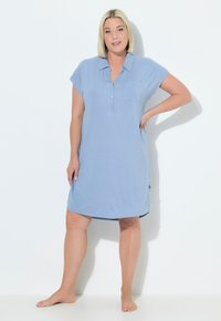 Vestito blu chiaro a maniche corte con collo abbottonato, dettagli con tasche e vestibilità rilassata. Tessuto morbido con una superficie liscia e aperture laterali.