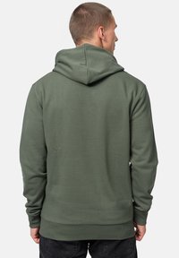 Felpa con cappuccio verde oliva in tessuto testurizzato, con polsini a coste e orlo a coste, dotata di tasca a marsupio e design con vestibilità rilassata.