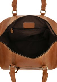 Bruine leren tas met twee handvatten aan de bovenkant, een ritsafsluiting en een gladde buitenkant. De binnenkant is van donker stof met een ritsvak.