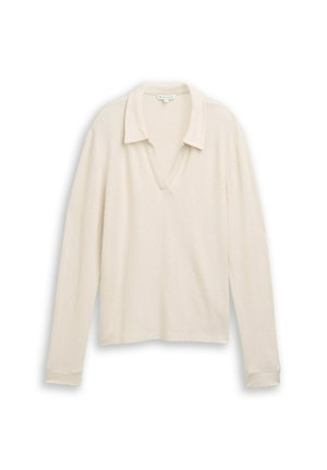Polo à manches longues en tricot couleur crème, doté d'un col en V et d'une texture douce avec une coupe décontractée. Détails au niveau du col et des poignets inclus.