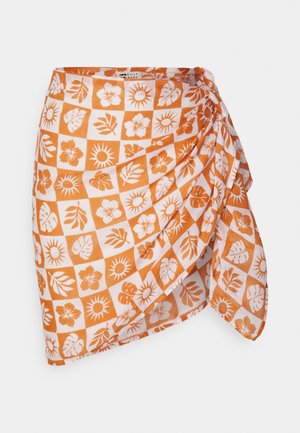 Wickelrock in Orange und Weiß mit kariertem Muster und Blumen- sowie Sonnenmotiven. Hergestellt aus leichtem Stoff mit einem drapierten Design.