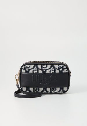 Schwarz-weiß gemusterte Stofftasche mit glattem schwarzen Lederakzent, goldenem Reißverschluss und abnehmbarem Trageriemen. Die Maße sind kompakt und rechteckig.