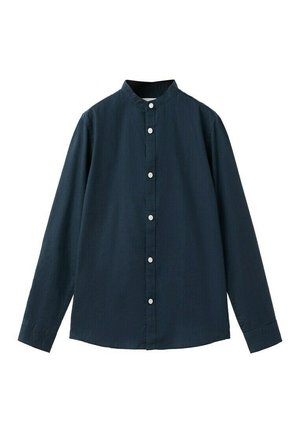 Chemise bleu marine à manches longues avec un col montant et des boutons blancs sur le devant.