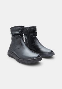 Bottines en cuir noir avec un tige froncée et une fermeture éclair sur le côté. Elles possèdent une finition texturée et une semelle en caoutchouc flexible avec des détails de couture.