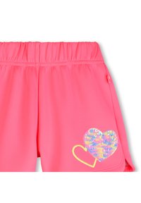 Ροζ σορτς με ελαστική ζώνη στη μέση, με σχέδιο καρδιάς από πολύχρωμους παγιέτες και κίτρινες κεντητές λεπτομέρειες.