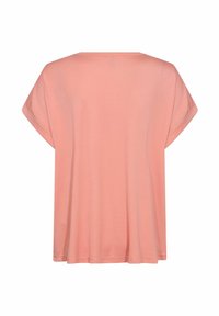 T-shirt rose à côtes avec une coupe ample, des manches courtes larges et un col arrondi. Texture lisse et couture propre visible.