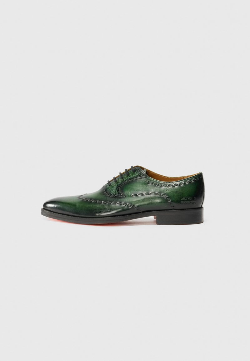 Green leather oxford shoe with intricate stitching, rounded toe, textured accents, and a black sole with a subtle red edge.