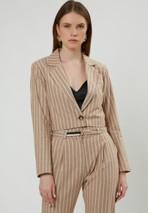 Blazer beige a righe con un solo bottone, vestibilità sagomata e maniche lunghe, abbinato a pantaloni a vita alta coordinati con una cintura.