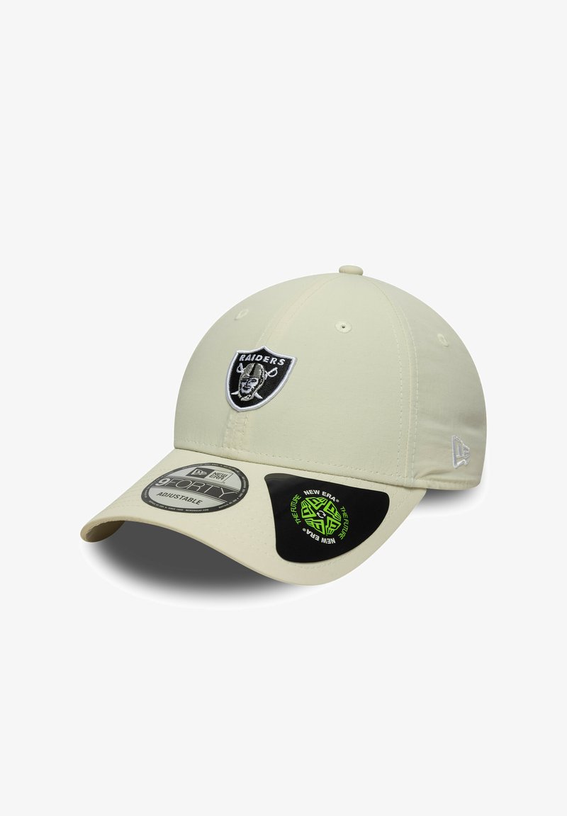 Gorra de béisbol beige con el logo de los Raiders bordado en la parte delantera. Presenta una visera curvada y una correa trasera ajustable. Textura suave.