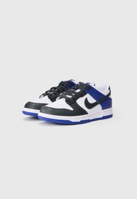 Czarne, białe i niebieskie sneakersy niskie z materiałów skórzanych i syntetycznych; posiadają perforowaną cholewkę, wyściełany kołnierz i gumową podeszwę.