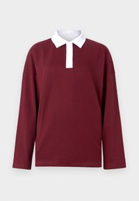 Bordo ilgomis rankovėmis polo marškiniai su balta apykakle, mygtukų užsegimu ir minkšta medvilne, turintys laisvą siluetą ir minimalizmą.