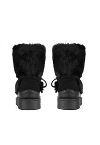 Schwarze Stiefel mit einem weichen, pelzigen Oberteil und einem glatten Lederschaft. Sie haben eine runde Form und eine flache Gummisohle. Verstellbare Schnürsenkel an der Rückseite.