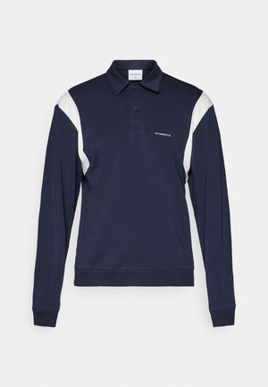 Navy long-sleeve polo shirt with white accent panels, a classic collar, two buttons, and embroidered branding on the chest. Soft cotton blend.