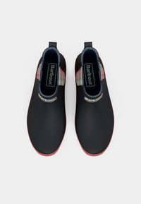 Μαύρα δερμάτινα μποτάκια αστραγάλου με κόκκινες σόλες, καρό λεπτομέρειες στα πλάγια, ενισχυμένες θηλιές στη φτέρνα και το λογότυπο Barbour στην εσωτερική επένδυση.