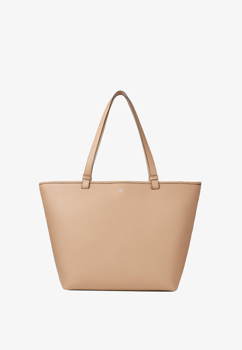 Sac cabas en cuir beige avec deux longues anses et petit logo blanc centré près du haut.